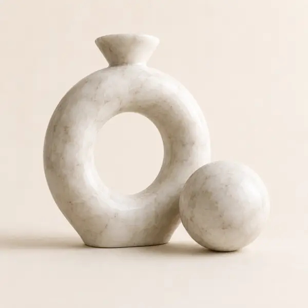 Beige natural marble knot sculpture with matching marble sphere on a neutral background.