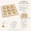 Luxury marble tic tac toe game set styled on a coffee table with home decor.