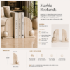 Beige marble bookends holding books on a table in an elegant living room setting.
