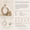 Luxury marble knot sculpture and marble sphere styled on books in a modern living room.