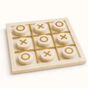 Luxury marble tic tac toe game set with brass inlay and cream marble playing pieces.