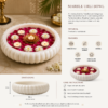 White marble urli bowl filled with floating rose petals, flowers, and lit candles.